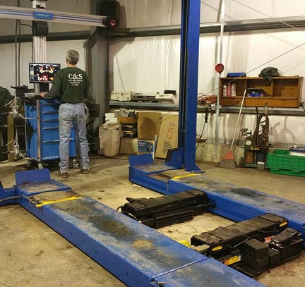 Truck and car wheel alignment equipment. Doug Sanna, back-to, at control panel.